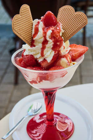 Strawberry cup with fresh strawberries on vanilla ice cream in a German ice cream parlorの写真素材