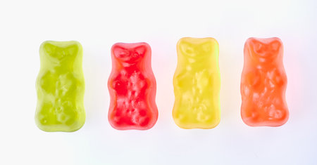 four gummy bears in different colors on white backgroundの写真素材