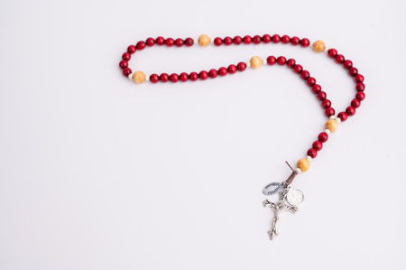 The rosary is made of red and yellow beads and has a crucifix.の写真素材
