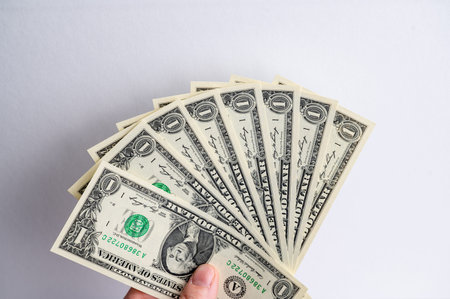 one dollar bills are fanned out in a hand.
