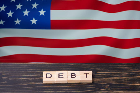 Letters spell debt with an American flag in the backgroundの写真素材