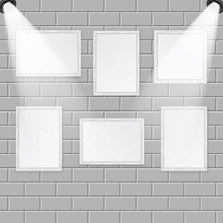 Art gallery and spotlights with place for your design.A set of wooden frames for paintings and photos on the brick wall are illuminated by lampsのイラスト素材