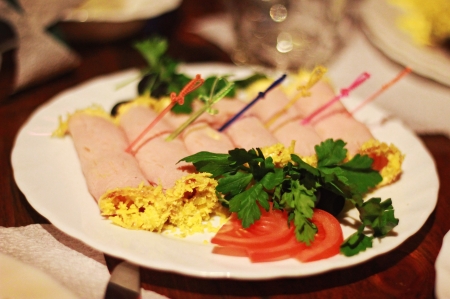 ham rolls and cheese with tomatoes,lie on a white plate, canapesの写真素材