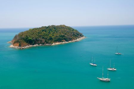 Tiny island in Phuket, Thailand, with four visiting boats.の写真素材