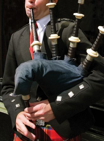 Bagpiper blowing his pipes in Edinburgh, Scotland Bagpiper blowing his pipes in Edinburgh, Scotland