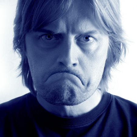 A mad / sad man with huge frown and angry eyes.  