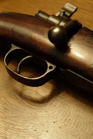 Very shallow depth of field image of the trigger of an old shotgun.  Focus is on the tip of the...