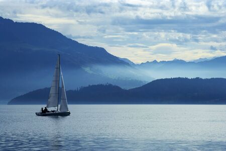 Sailing on Lake Zug in Switzerland with the Alps in the background.の写真素材