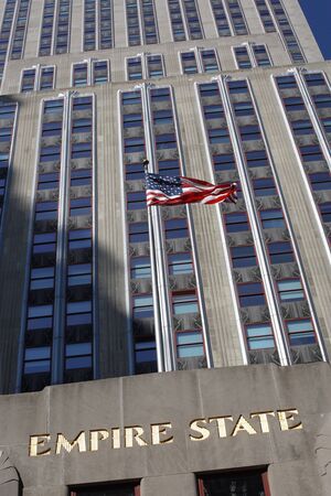 New York City, New York, USA - October 7, 2010: American flag blowing in the wind in front of the Empire State Building on 5th Ave., Manhattan.のeditorial素材