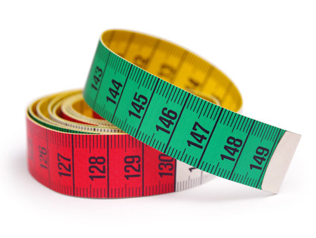 Closeup photo of a yellow, red, and green tape measure. Shallow depth of field.
