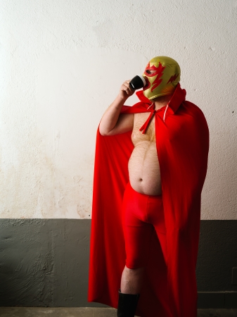 Photograph of a Mexican wrestler or Luchador drinking coffee before his fight.
の写真素材