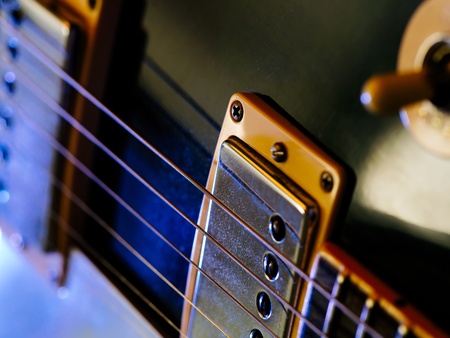 Macro abstract photo of the pickups and strings of an electric guitar  Shallow depth of field with focus on the first string の写真素材