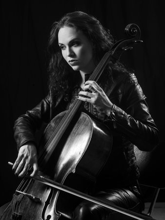 Photo of a beautiful female musician playing a cello.の写真素材