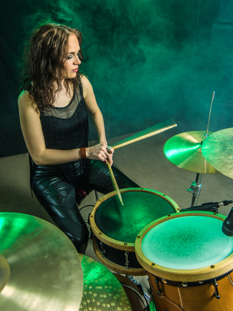 Photo of a beautiful woman playing her drum set on stage.の写真素材