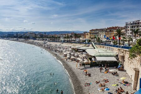 Nice, France - July 17, 2019: People sunbathing on the beach along French riviera in Nice, France.のeditorial素材