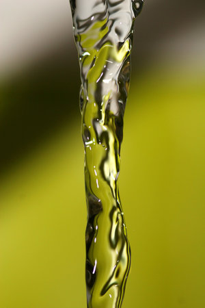 A line of water streaming down with green backgroundの写真素材
