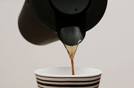cropped shot of coffee being poured in cupの写真素材
