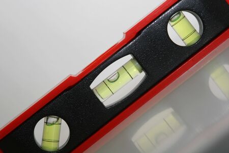 cropped and tilted shot of a bevel lying on white reflective surfaceの写真素材