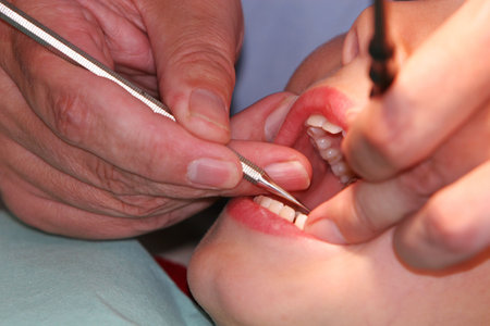 A young boy at the dentists, dentist taking a look into his mouth using various tools