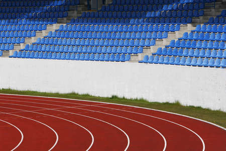 Sports stadium, running track and blue seats for spectatorsの写真素材