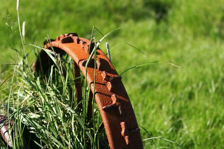 An old rusty iron wheel from farm machinery,  shallow focus, abstract の写真素材