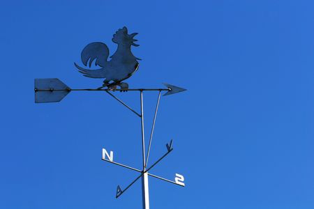 Indicator of wind direction, with figure of rooster on top, east, sout, west and north represented with lettersの写真素材