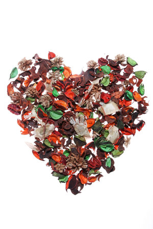Pot pourri perfumed leaves and petals in the shape of a heart, isolated on whiteの写真素材