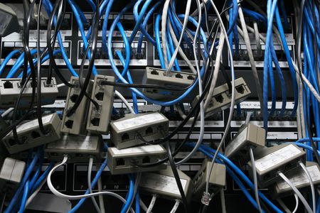 chaotic mess of network cables all tangled togetherの写真素材