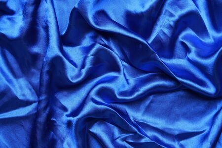 Blue colored satin shot from above with creases and folds creating all sorts of shapes and shadowsの写真素材