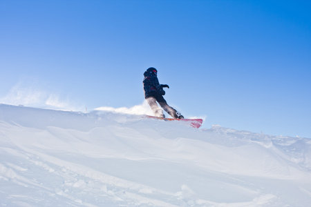 Young man snowboarding in sunshine and perfect weatherの写真素材