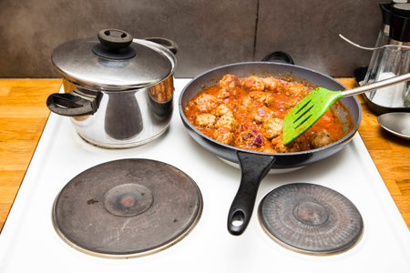 Dinner cooking on the stove in a real home kitchen, gritty and messyの写真素材