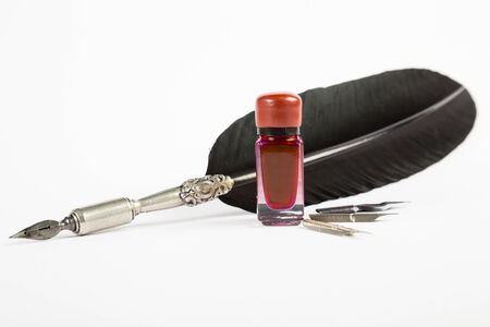 Feather quill isolated on white with red ink wellの写真素材