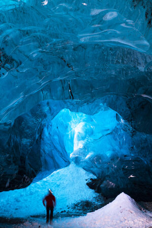 Person hiking inside an icecave in south iceland, person is motion blurredの写真素材