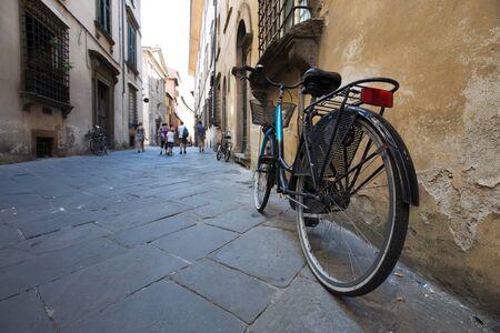 Street scene in a European town, bicycle in the foreground with pedestrians in the backgroundの写真素材
