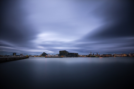 Long exposure shot of Harpa concert hall by the Reykjavik Harbor. shot late at night with dramatic skies overheadの写真素材