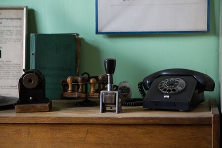 Shot of items on a wooden desk, old telephone and vintage itemsの写真素材