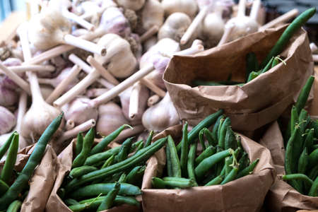 Garlic and Green beans in paper bags at a farmers market after harvestの写真素材