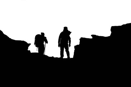 silhouette of people hiking up a mountain, set against a dramatic skyの写真素材