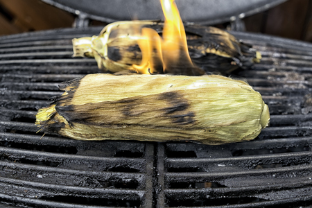Corn cobs on the grill , flames coming of one of them.の写真素材