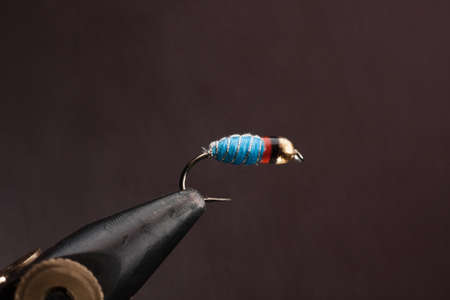 Macro shot of a fly fishing hook with a blue and white colorの写真素材