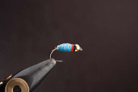 Close-up of a fishing hook with a fishing rod on a black backgroundの写真素材