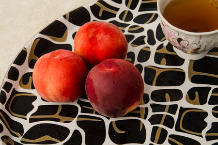peaches on a tray and a cup of teaの写真素材