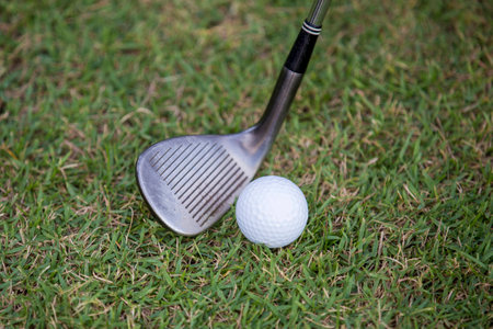 Golf ball about to be hit with iron clubの写真素材