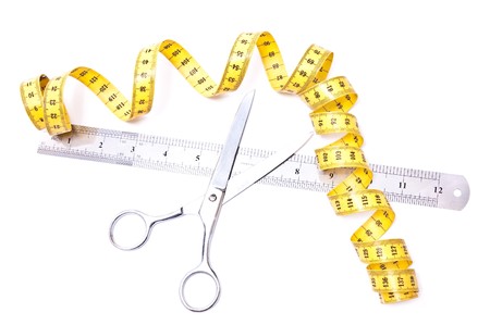 Yellow centimetre and steel scissors isolated on whiteの写真素材