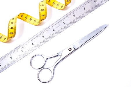 Yellow centimetre and steel scissors isolated on whiteの写真素材