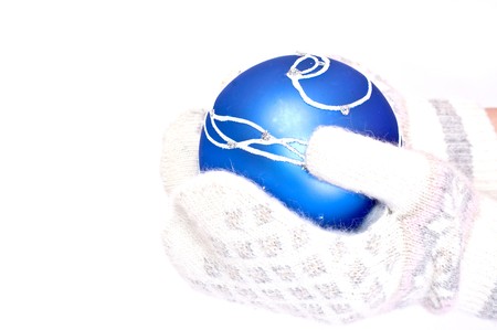 Blue Christmas toy in hands with mitten on whiteの写真素材