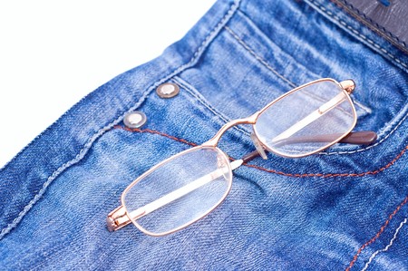Glasses in blue jeans pocket on white backgroundの写真素材