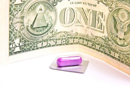 One red pill with one dollar isolated on white.の写真素材
