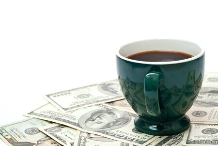 Cup of coffee on money isolated on whiteの写真素材
