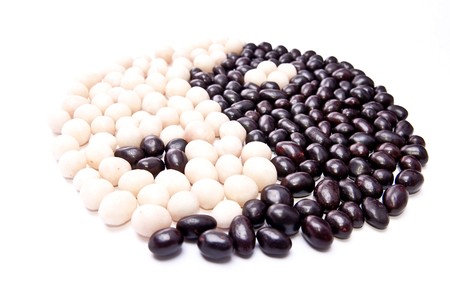 Yinyang symbol from peanuts in black and white chocolate. Isolated on whiteの写真素材